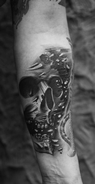 A skull tattoo on the arm of a man as an inspiration for tattoo designs for men arm. 