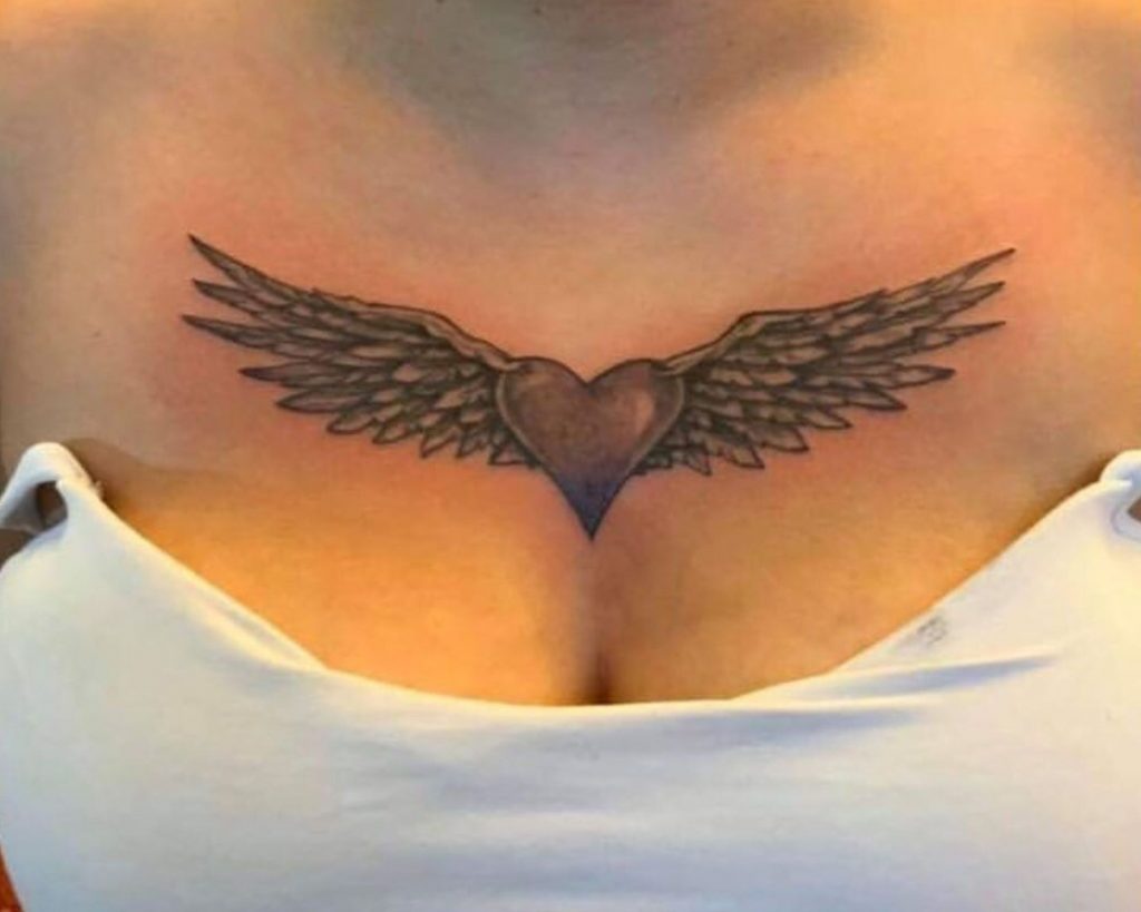 Heart with wings tattoo on the chest of a woman as an inspiration for heart for tattoo designs for you