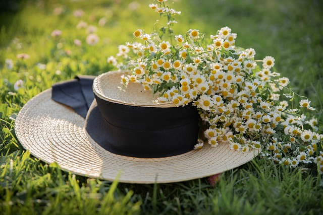 picture of a beige colored hat lying on the grass in a garden with flowers on it as decoration. 